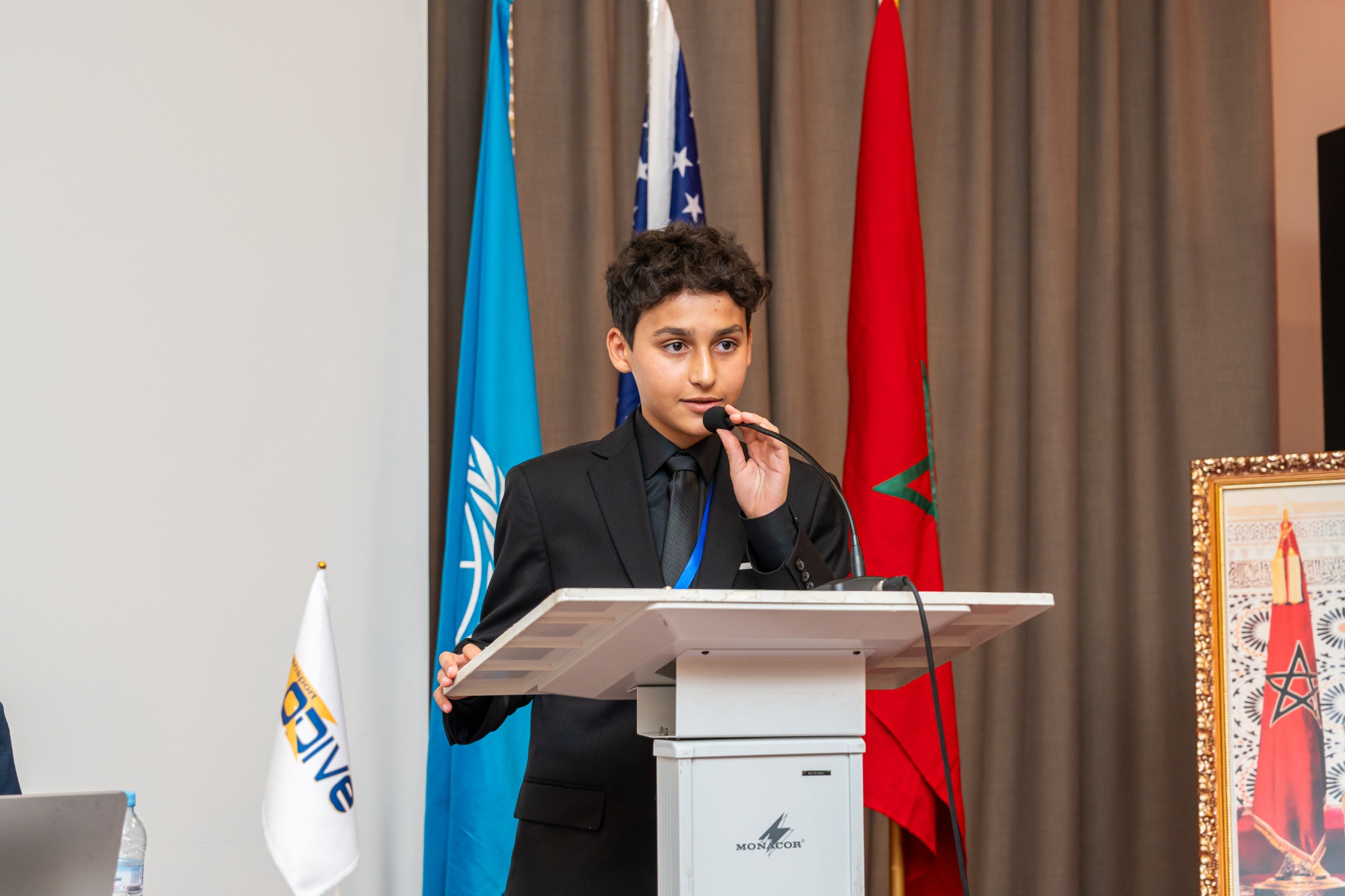 Omar speaking at a conference podium